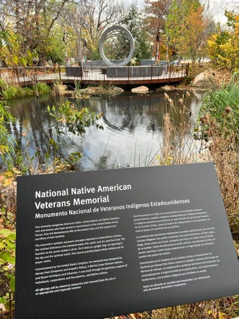 A placard informs visitors about the National Native American Veterans Memorial and its inspiration.