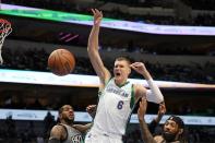 Dallas Mavericks center Kristaps Porzingis (6) loses control of the ball on a shot attempt as Brooklyn Nets' LaMarcus Aldridge, left, and DeAndre' Bembry, right, defend during the first half of an NBA basketball game in Dallas, Tuesday, Dec. 7, 2021. (AP Photo/Tony Gutierrez)
