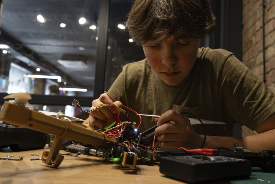 Misha Soboliev, 17, works on drone details in his school, in Kyiv, Ukraine, on May 1, 2024. He built a drone to send to his father's army unit. (AP Photo/Alex Babenko)