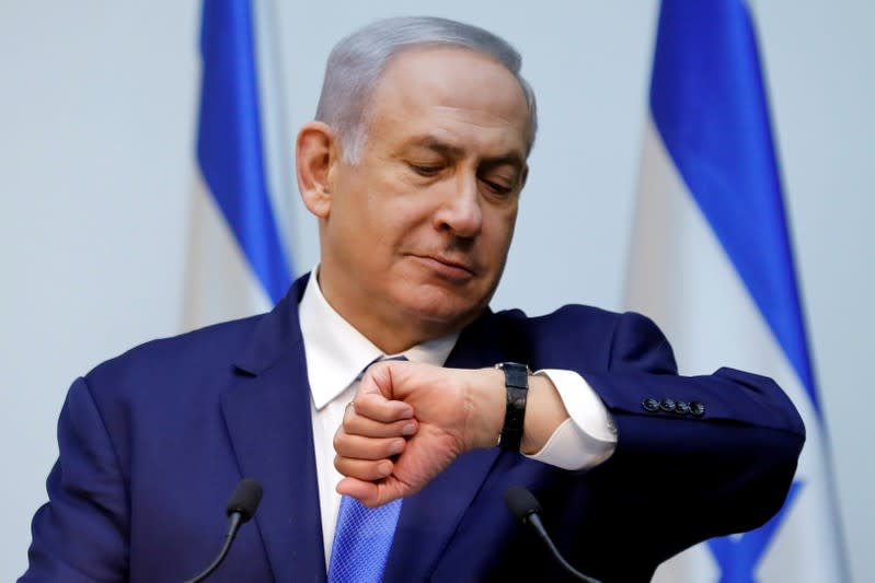 Foto de archivo. El primer ministro de Israel, Benjamin Netanyahu, mira su reloj antes de entregar una declaración en el Parlamento en Jerusalén