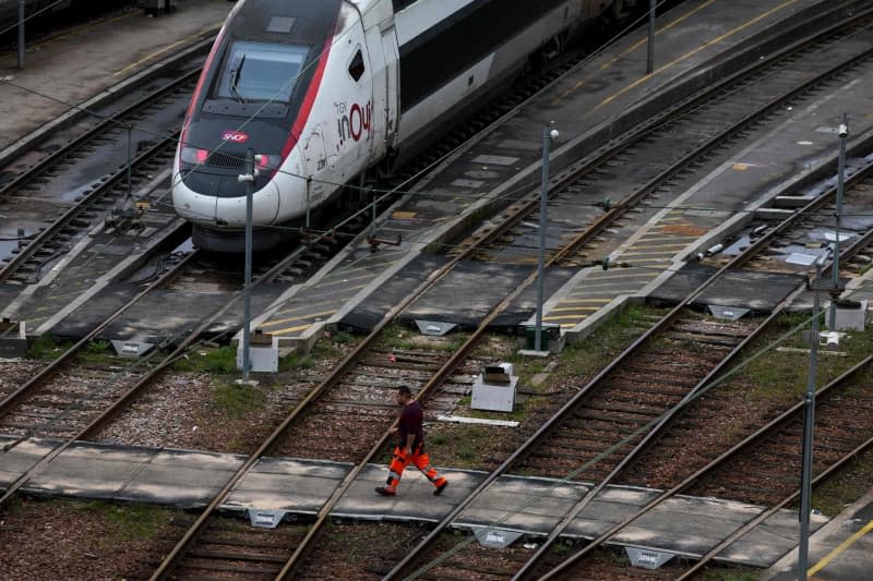 An employee walks on the Charenton-le-pont railway yard near an InOui high-speed TGV train, amid a ticket controller strike in Paris. Ian Langsdon/AFP/dpa