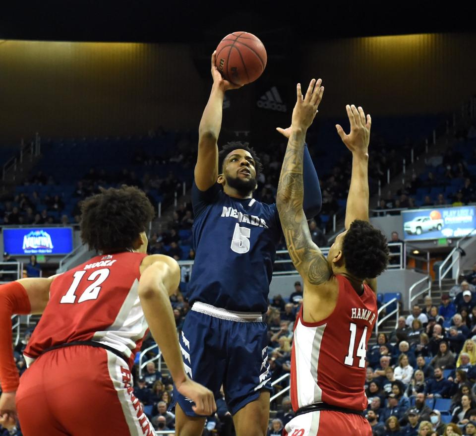 Nevada's Warren Washington shoots between UNLV's David Mouka, left, and Royce Hamm Jr. during Tuesday's game at Lawlor Events Center on Feb. 22, 2022.