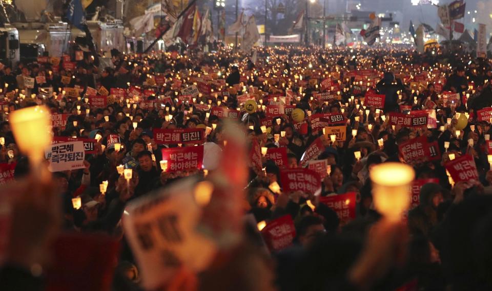 FILE - In this Nov. 19, 2016 file photo, South Korean protesters hold up candles during a rally calling for impeached South Korean President Park Geun-hye to step down in Seoul, South Korea. A lawyer for South Korea's disgraced president has compared her impeachment to the "unjust" deaths of Jesus Christ and the ancient Greek thinker Socrates. That might be over the top, but the country’s second impeachment trial will have major implications on the world’s 11th largest economy and its tense standoff with nuclear-armed North Korea. (AP Photo/Lee Jin-man, File)