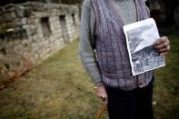 The grandson of Gavrilo Princip's brother, Miljkan Princip poses with a photo of Princip's house in front it in Bosansko Grahovo, January 31, 2014. REUTERS/Dado Ruvic