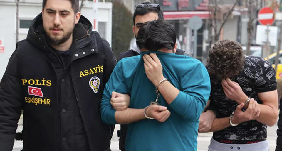 Hasan Fakioglu and another man being led away by police. Source: Hurriyet