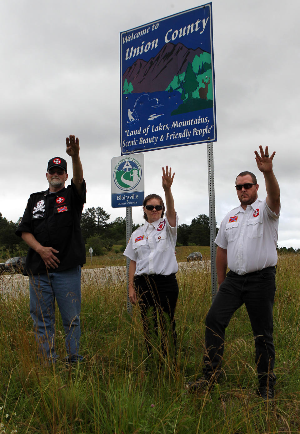 From left, Knighthawk, April Hanson and her husband Harley Hanson, members of the International Keystone Knights Realm of Georgia, perform a traditional Klan salute along the portion of highway they want to adopt allowing them to put up a sign and do litter removal near Blairsville, Ga., Sunday, June 10, 2012. The Ku Klux Klan group wants to join Georgia's "Adopt-A-Highway" program for litter removal, which could force state officials to make difficult decisions on the application. (AP Photo/The Atlanta Journal-Constitution, Curtis Compton)