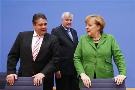 Party leaders German Chancellor Angela Merkel (R) of the Christian Democratic Union (CDU), Horst Seehofer (C) of the Christian Social Union (CSU) and Sigmar Gabriel of the Social Democratic Party (SPD) arrive for a news conference after signing a preliminary agreement, which has still to be approved by the members of the SPD, in the Bundespressekonferenz in Berlin, November 27, 2013. REUTERS/Thomas Peter