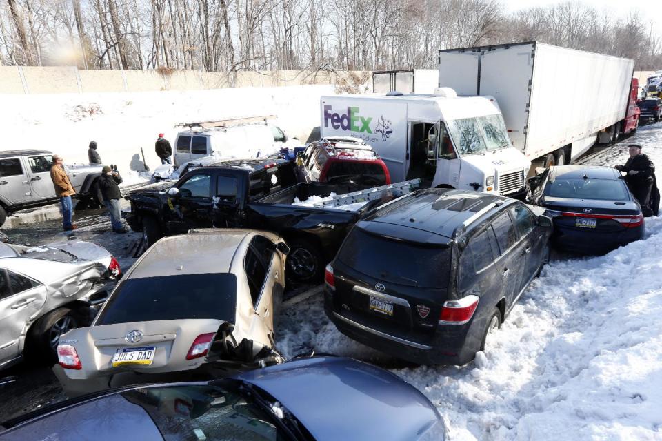 Vehicles are piled up in an accident, Friday, Feb. 14, 2014, in Bensalem, Pa. Traffic accidents involving multiple tractor trailers and dozens of cars have completely blocked one side of the Pennsylvania Turnpike outside Philadelphia and caused some injuries. (AP Photo/Matt Rourke)