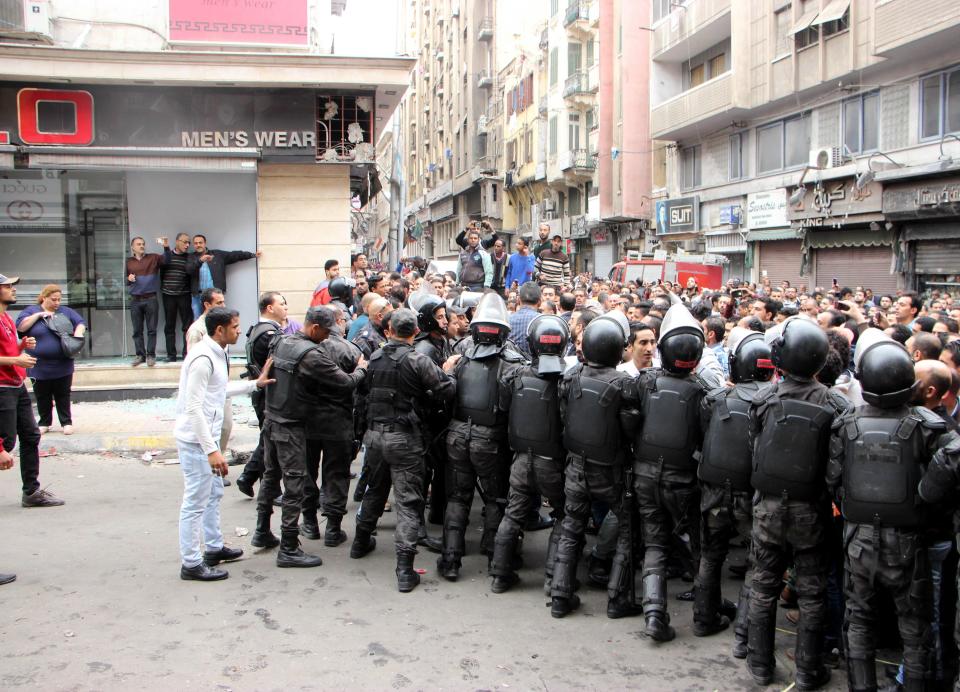 Police officers block the road as people gather to protest a bomb attack near St. Marks Cathedral in the coastal city of Alexandria, Egypt on April 9, 2017.