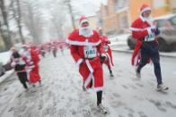 MICHENDORF, GERMANY - DECEMBER 09: Participants dressed as Santa Claus run through falling snow in the 4th annual Michendorf Santa Run (Michendorfer Nikolauslauf) on December 9, 2012 in Michendorf, Germany. Over 800 people took part in this year's races that included children's and adults' races. (Photo by Sean Gallup/Getty Images)