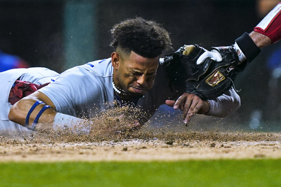 Chicago Cubs' Christopher Morel scores scores past Philadelphia Phillies' J.T. Realmuto during the 10th inning of a baseball game, Saturday, July 23, 2022, in Philadelphia. (AP Photo/Matt Rourke)