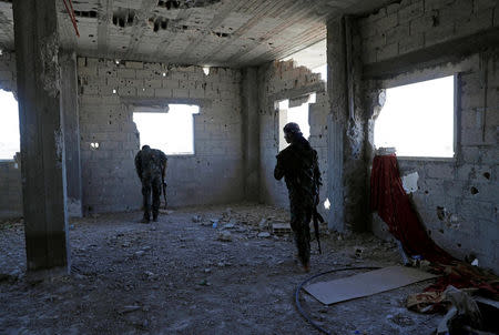 Members of Syrian Democratic Forces take up positions inside a building as they battle Islamic State militants in Raqqa, Syria October 1, 2017. REUTERS/Erik De Castro