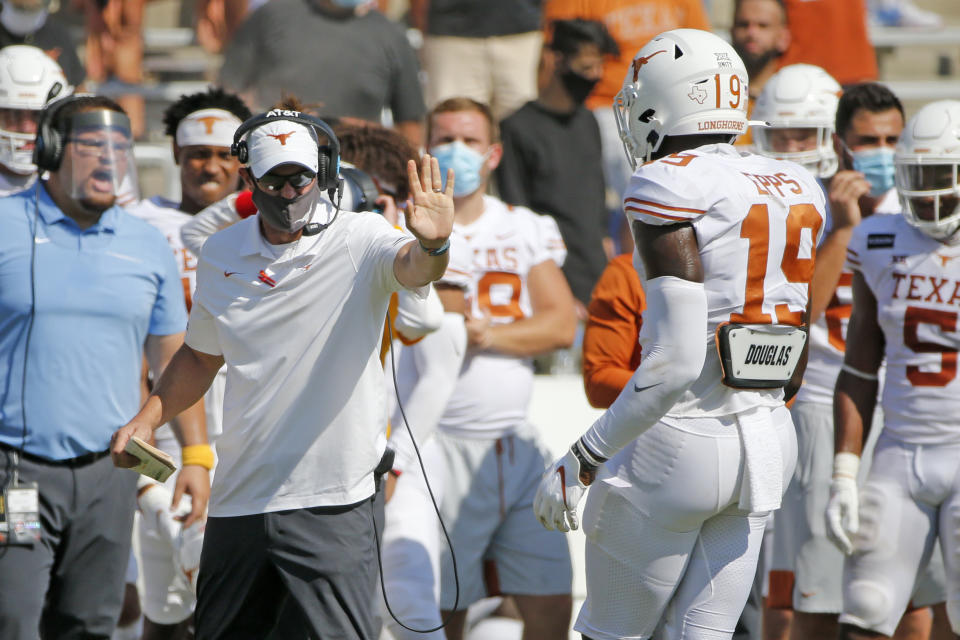 Texas head coach Tom Herman gives instructions to Texas tight end Malcolm Epps (19) during overtime of an NCAA college football game in Dallas, Saturday, Oct. 10, 2020. Oklahoma defeated Texas 53-45 in overtime.(AP Photo/Michael Ainsworth)