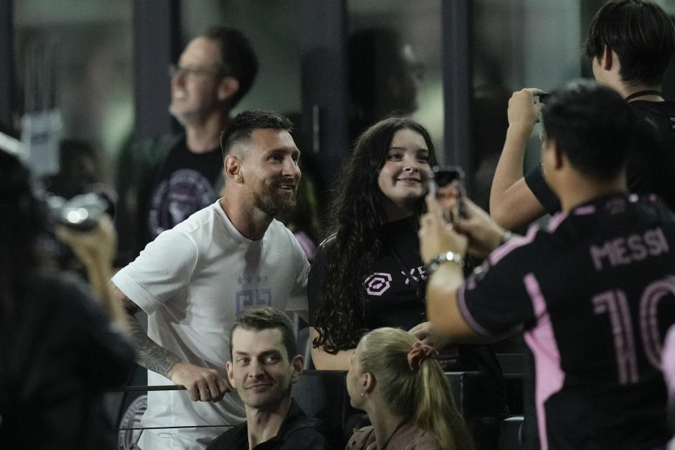 Inter Miami forward Lionel Messi, left, poses for pictures with fans after an MLS soccer match between Inter Miami and Charlotte FC, Wednesday, Oct. 18, 2023, in Fort Lauderdale, Fla. (AP Photo/Rebecca Blackwell)