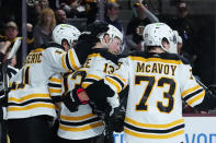 Boston Bruins center Charlie Coyle (13) celebrates his goal against the Arizona Coyotes with defenseman Charlie McAvoy (73) and center Trent Frederic, left, during the second period of an NHL hockey game in Tempe, Ariz., Friday, Dec. 9, 2022. (AP Photo/Ross D. Franklin)