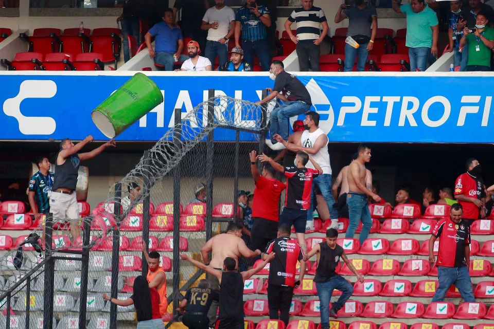 Supporters of Atlas fight with supporters of Queretaro during the Mexican Clausura tournament football match between Queretaro and Atlas at Corregidora stadium in Queretaro, Mexico on March 5, 2022. - A match between Mexican football clubs was called off March 5, 2022 after violence by opposing fans spilled onto the field. The game between Queretaro and Atlas at La Corregidora stadium in the city of Queretaro  -- the ninth round of the 2022 Clausura football tournament -- was in its 63rd minute when fights between opposing fans broke out. (Photo by EDUARDO GOMEZ / AFP) (Photo by EDUARDO GOMEZ/AFP via Getty Images)