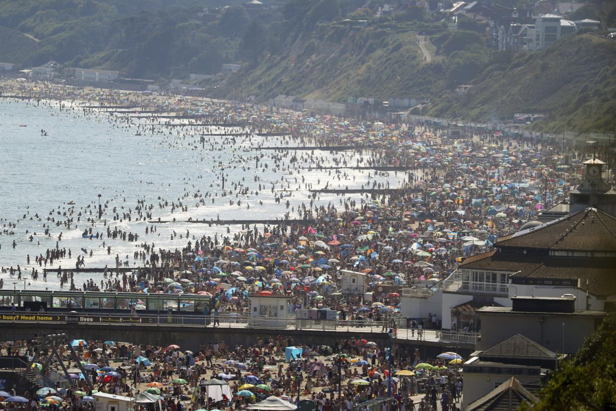 People are seen on the beach on the hottest day of the year after an easing of social restrictions due to coronavirus in Bournemouth, England on Wednesday, June 24, 2020. Temperatures reached 32.6C (90.7F) at London's Heathrow Airport on Wednesday.