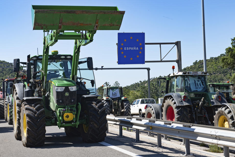 Tractors drive on the A7 highway at the Le Perthus French-Spanish border Monday, June 3, 2024. Farmers from Catalonia are blocking the major road route between Spain and France in northern Catalonia complaining that they are being put out of business by restrictions and need more subsidies. (Gloria Sanchez/Europa Press via AP)