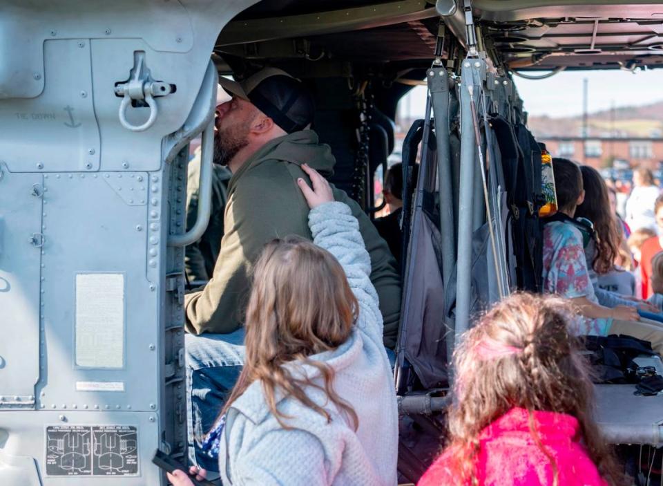 Lance Cpl. USMC retired Aaron King is comforted by his daughters Layla Blair-King and Leah Blair-King as he sits in one of the MH-60S helicopters that were flown in to the Bald Eagle Area Veterans Day celebration on Thursday, Nov. 9, 2023. Abby Drey/adrey@centredaily.com