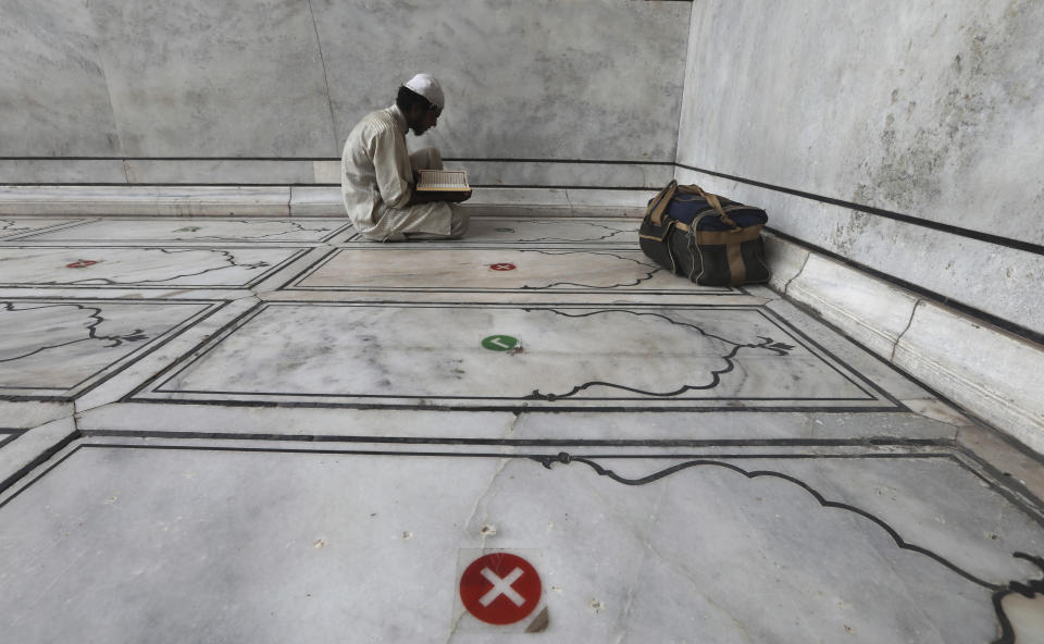 An Indian Muslim offers prayers on the eve of Eid al-Adha with social distancing marking on the floor at Jama Masjid in New Delhi, India, Friday, July 31, 2020. Eid al-Adha, or the Feast of the Sacrifice, is marked by sacrificing animals to commemorate the prophet Ibrahim's faith in being willing to sacrifice his son. (AP Photo/Manish Swarup)