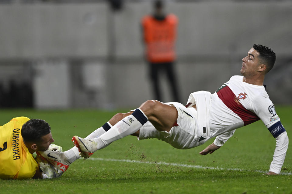 Portugal's Cristiano Ronaldo fouls Slovakia's goalkeeper Martin Dubravka during the Euro 2024 group J qualifying soccer match between Slovakia and Portugal at the National Football Stadium in Bratislava, Slovakia, Friday, Sept. 8, 2023. (AP Photo/Radovan Stoklasa)