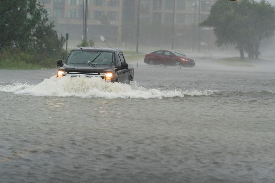 A motorist drives though high water, as another turns around during the effects from Hurricane Ian, Friday, Sept. 30, 2022, in Charleston, S.C. (AP Photo/Alex Brandon)