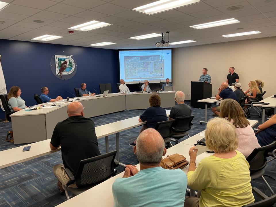 Matt Neumann (to right of podium) and Brian Lindgren (at podium) share two concepts for the Thomas farm property in the town of Delafield.