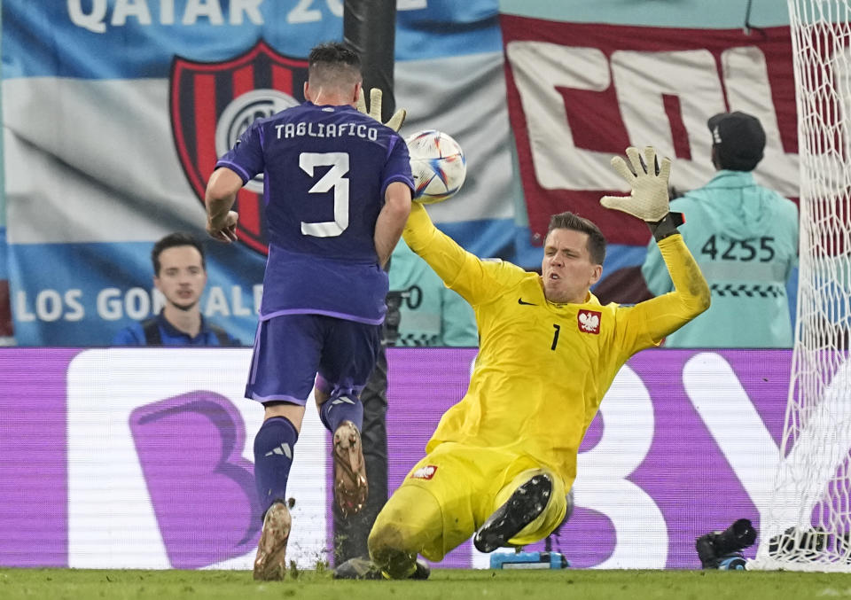 Poland's goalkeeper Wojciech Szczesny, right, makes a save in front of Argentina's Nicolas Tagliafico during the World Cup group C soccer match between Poland and Argentina at the Stadium 974 in Doha, Qatar, Wednesday, Nov. 30, 2022. (AP Photo/Ariel Schalit)