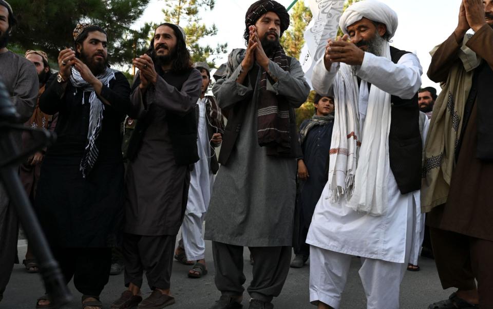 Taliban members dance as they celebrate the first anniversary of the withdrawal of US-led troops