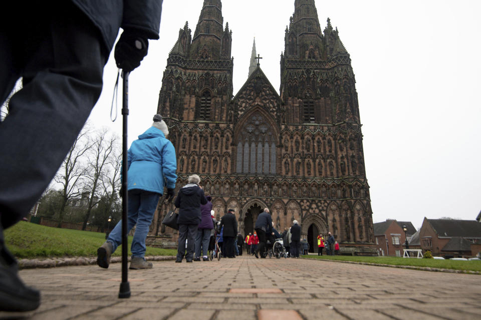 Members of the public queue to receive a dose of the Oxford/AstraZeneca coronavirus vaccine at Lichfield Cathedral, in Staffordshire, England, Friday, Jan. 15, 2021. The U.K. is ramping up its mass vaccination program as the government seeks to protect the country’s oldest and most vulnerable residents before easing a third national lockdown. (Jacob King/PA via AP)