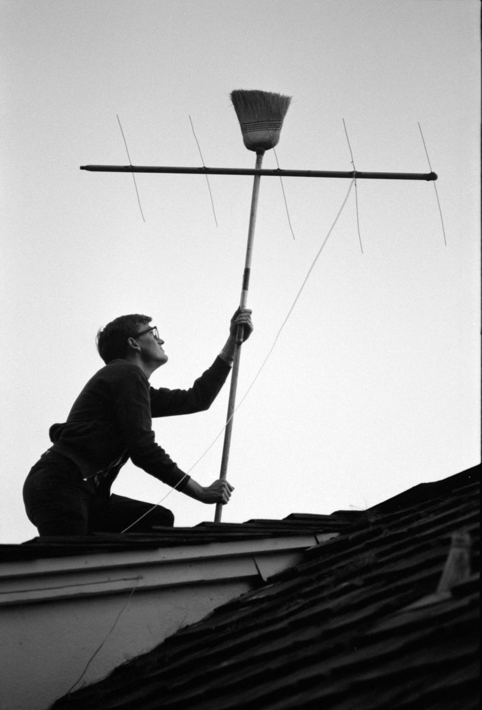 A football fan uses a broom on the roof of his house to try to improve reception in Los Angeles. The league's governing body required the game to blacked out in the local market, so residents attempted to access the broadcast from other cities.<span class="copyright">Bill Ray—The LIFE Picture Collection/Shutterstock</span>