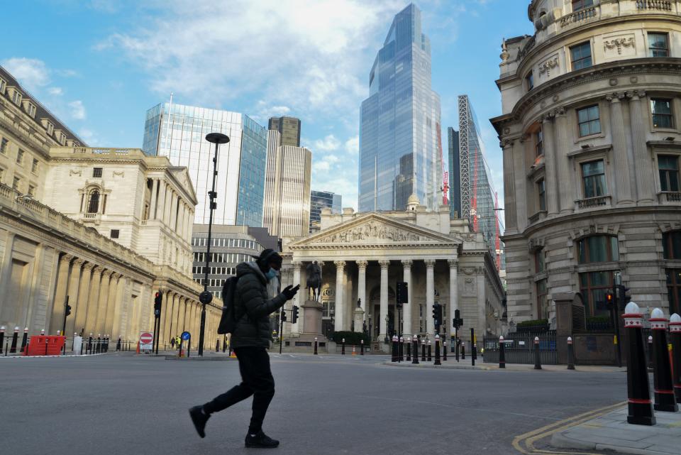 LONDON, UNITED KINGDOM - 2021/02/11: A man wearing a facemask as a precaution against the spread of covid 19, walks across the street opposite the Bank of England. (Photo by Thomas Krych/SOPA Images/LightRocket via Getty Images)