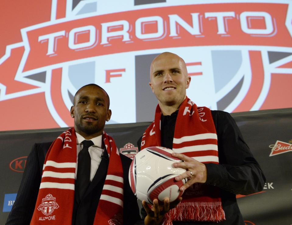 New Toronto FC soccer players Jermain Defoe, left, and Michael Bradley pose during a news conference in Toronto, Monday, Jan. 13, 2014. (AP Photo/The Canadian Press, Frank Gunn)