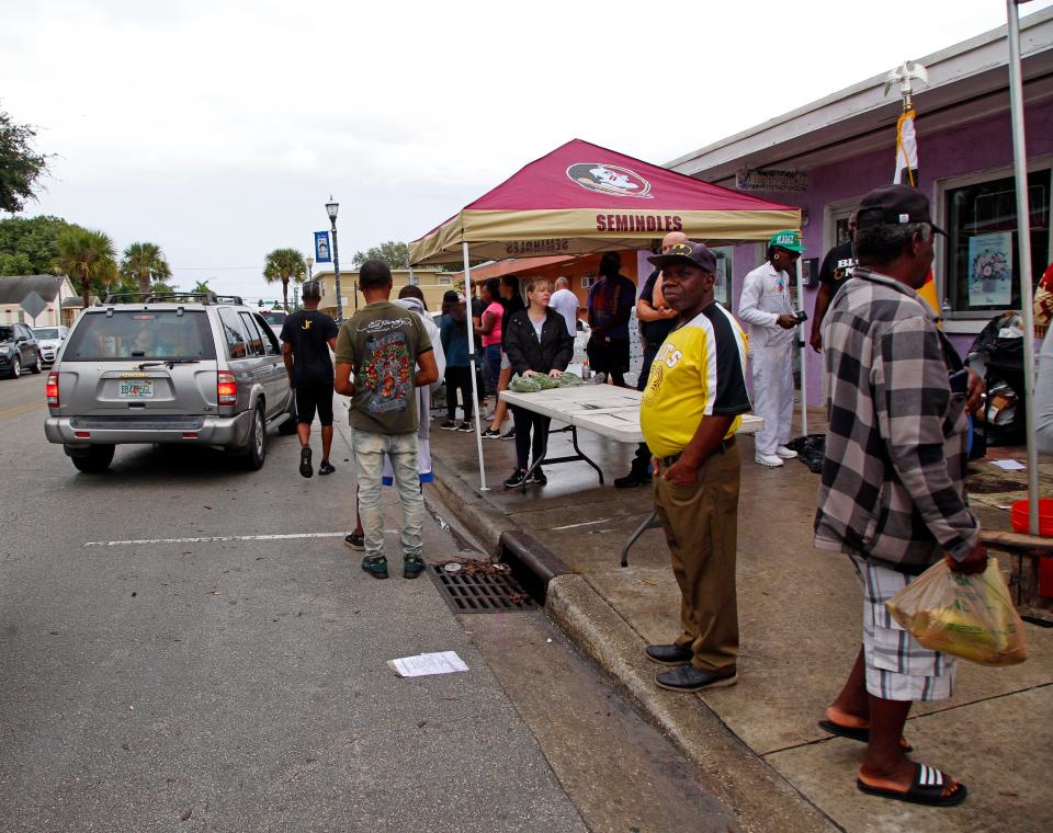 People from the Lincoln Park community line up along Avenue D outside of Sylvia's Flower Patch II for a food distribution two days before Thanksgiving on Tuesday, Nov. 22, 2022, in Fort Pierce.