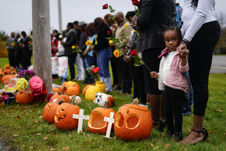 Members of the New Apostolic Church pray at a makeshift memorial outside a bowling alley, the site of one of this week's mass shootings, Sunday, Oct. 29, 2023, in Lewiston, Maine. A gunman killed multiple people at the bowling alley and a bar in Lewiston on Wednesday. (AP Photo/Matt Rourke)