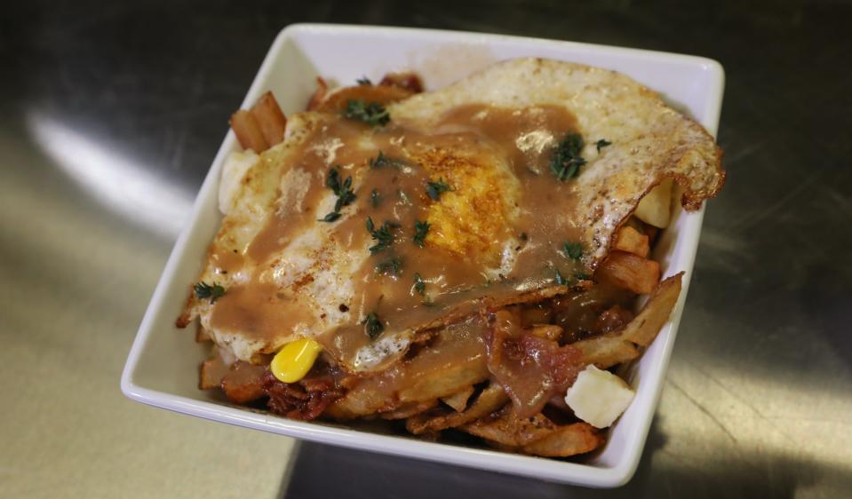 The breakfast poutine at the Petit Poutinerie in Rochester features a fried egg, along with french fries, beef gravy, cheese curds and fresh thyme.