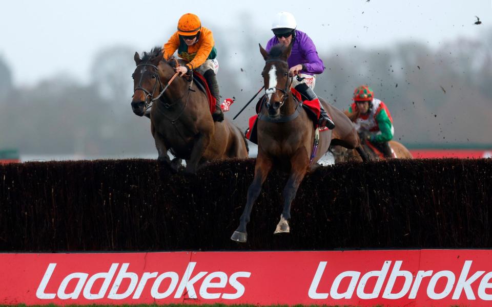 Five Star Getaway ridden by jockey Nick Scholfield (right) overtakes Fortescue ridden by jockey Richard Patrick before going on to win the Play Ladbrokes 1-2-Free On Football Handicap Chase at the Ladbrokes Christmas Festival at Kempton Park