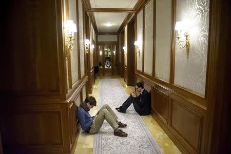 Reporters sit in a hallway as they wait during negotiations on Iran's nuclear programme at the Beau Rivage Palace Hotel in Lausanne, March 31, 2015. REUTERS/Brendan Smialowski/Pool