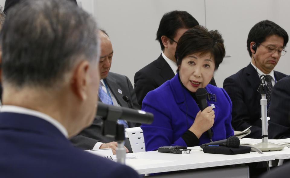 Tokyo Gov. Yuriko Koike, center, speaks with Tokyo Olympics Organizing Committee President Yoshiro Mori, left, at the Four-Party Working Group meeting in Tokyo, Wednesday, Dec. 21, 2016. Japanese Olympic organizers presented their first official cost estimate for the 2020 Tokyo Games at a level slightly below their promised 2 trillion ($17 billion) cap. (AP Photo/Shizuo Kambayashi)