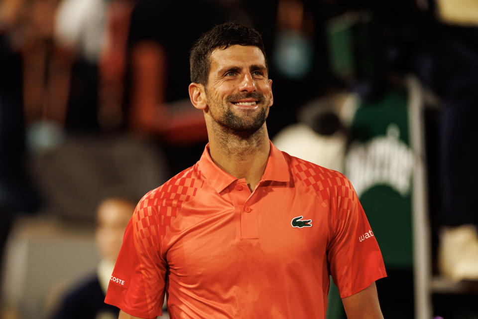 Novak Djokovic smiles after winning.