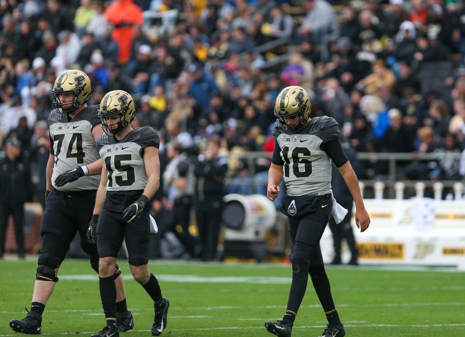 Purdue Boilermakers offensive lineman Eric Miller (74), wide receiver Charlie Jones (15), and quarterback Aidan O'Connell (16) walk onto the field with their heads down during the NCAA football game, Saturday, Nov. 5, 2022, at Ross-Ade Stadium in West Lafayette, Ind.