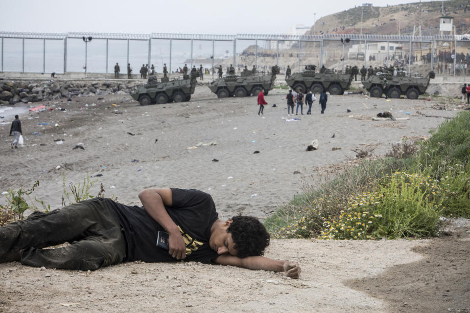 A man lies on the ground after arriving in the Spanish territory at the border of Morocco and Spain, at the Spanish enclave of Ceuta, on Tuesday, May 18, 2021. (AP Photo/Javier Fergo)