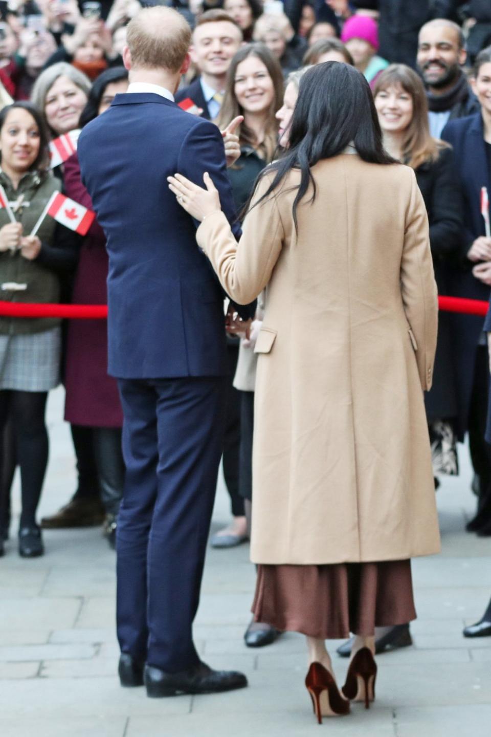 The affectionate couple stayed close as they greeted the crowd, with Meghan placing a hand on her husband's back.