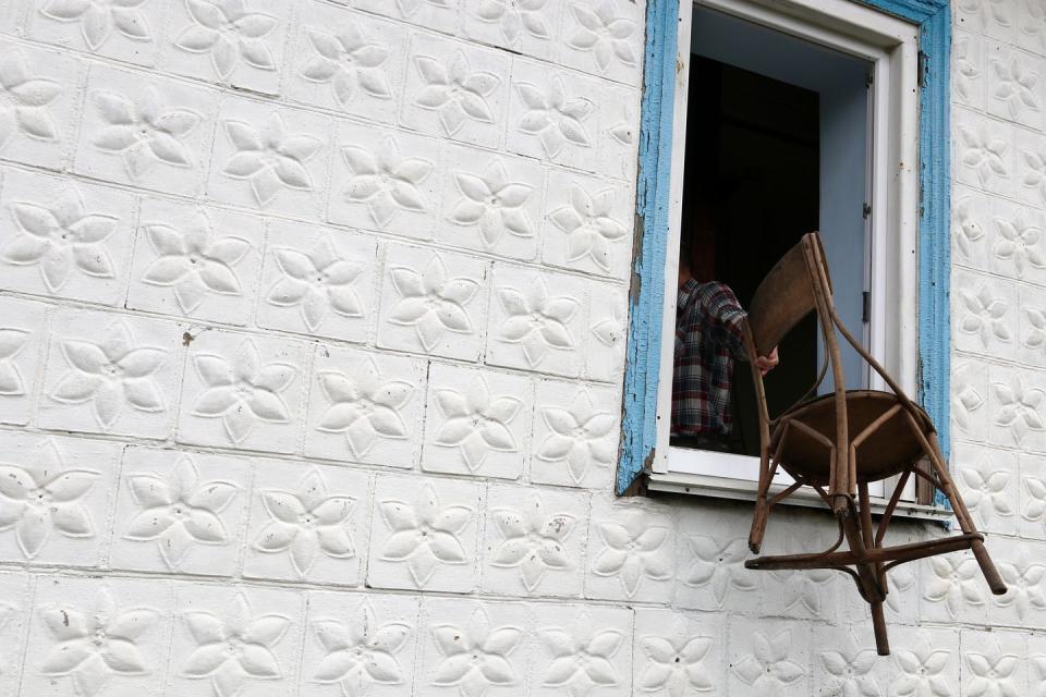 a man throws an old chair out of the window