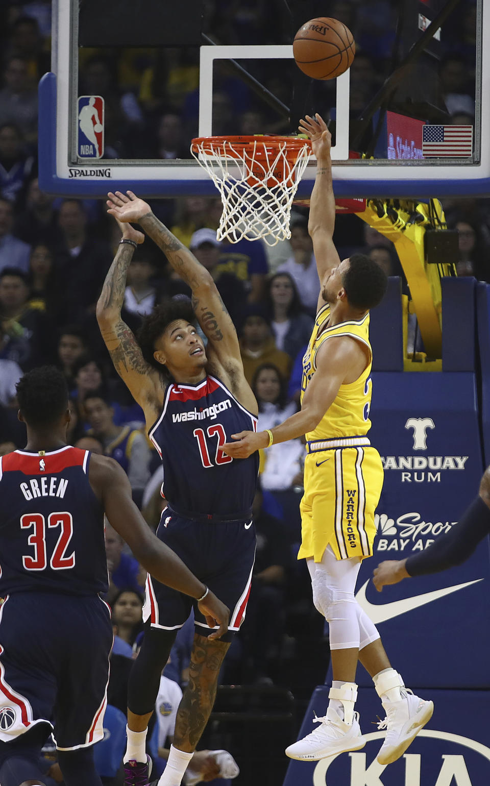 Golden State Warriors' Stephen Curry, right, lays up a shot over Washington Wizards' Kelly Oubre Jr. (12) during the first half of an NBA basketball game Wednesday, Oct. 24, 2018, in Oakland, Calif. (AP Photo/Ben Margot)