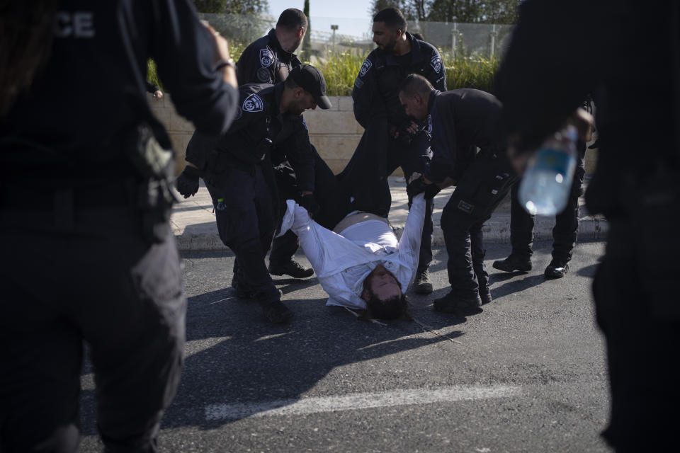 Israeli police officers remove an ultra-Orthodox Jewish man from the street during a protest against army recruitment in Jerusalem, Sunday, June 2, 2024. Israel's Supreme Court is hearing the cases against the military enlistment exemptions of ultra-Orthodox Jewish men as the Israeli military's manpower has been strained by the nearly eight-month-long war against Hamas in Gaza. Its decision is expected in the coming weeks. (AP Photo/Leo Correa)