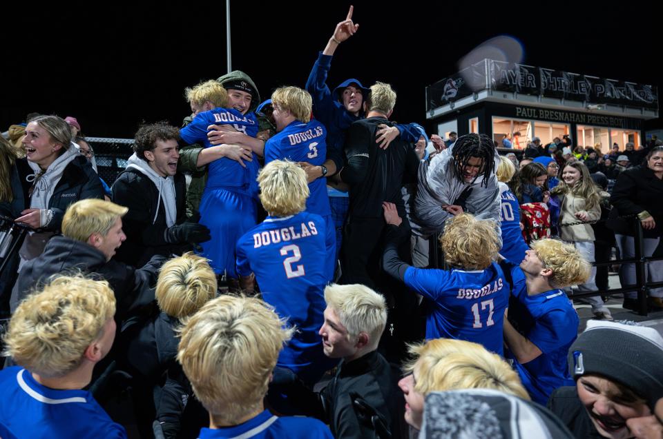 Douglas boys' soccer players celebrate their victory over Bromfield in the stands after a Division 5 state semifinal.