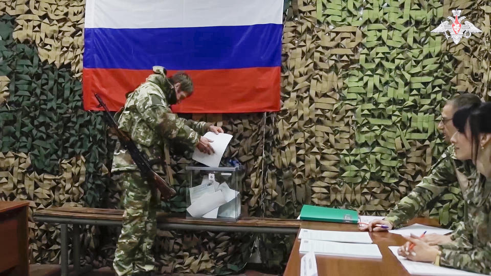 In this photo taken from video released by Russian Defense Ministry Press Service on Monday, March 4, 2024, a Russian serviceman votes at an improvised pooling station during early voting in the Russian presidential elections in the Russian-controlled Donetsk region, eastern Ukraine. (Russian Defense Ministry Press Service via AP)