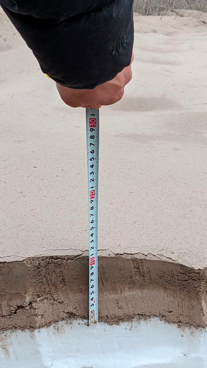 A measuring tape shows how thick the debris settled in some areas.