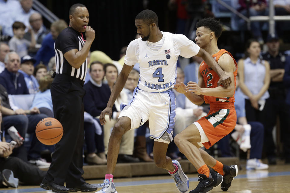 North Carolina guard Brandon Robinson (4) chases the ball with Miami guard Isaiah Wong (2) during the second half of an NCAA college basketball game in Chapel Hill, N.C., Saturday, Jan. 25, 2020. (AP Photo/Gerry Broome)